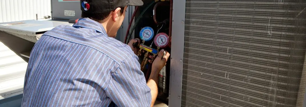 HVAC technician servicing a condenser unit in Tullahoma